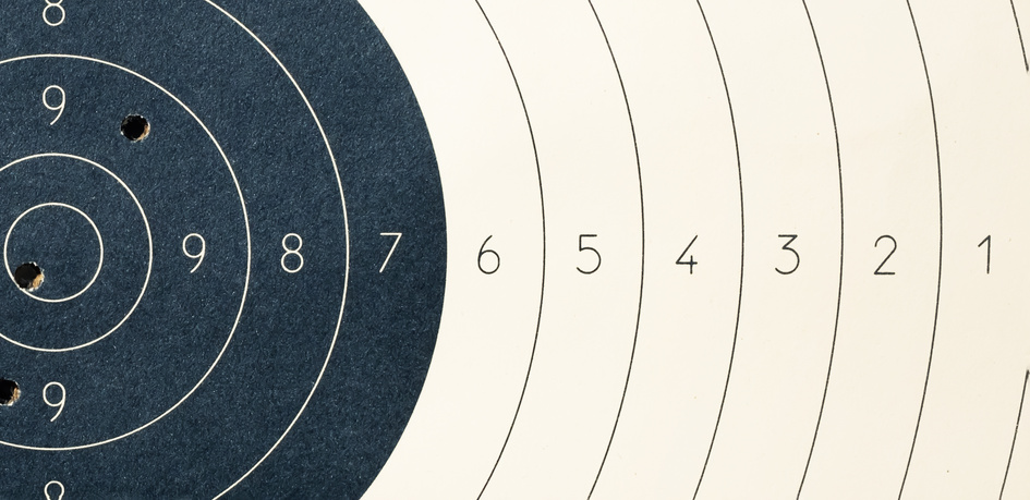 Target with numbers for shooting at a shooting range. A round target with a marked bull's-eye for shooting practice on the shooting range. Target with bullet holes.